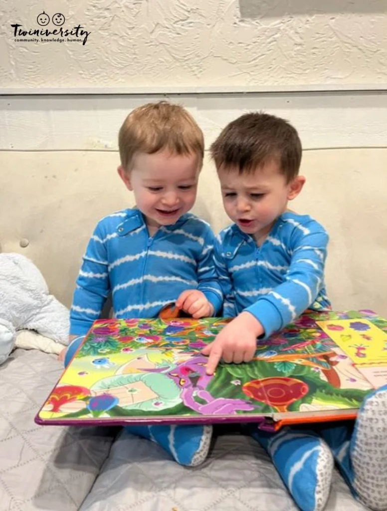 2 year old twin boys reading a book together