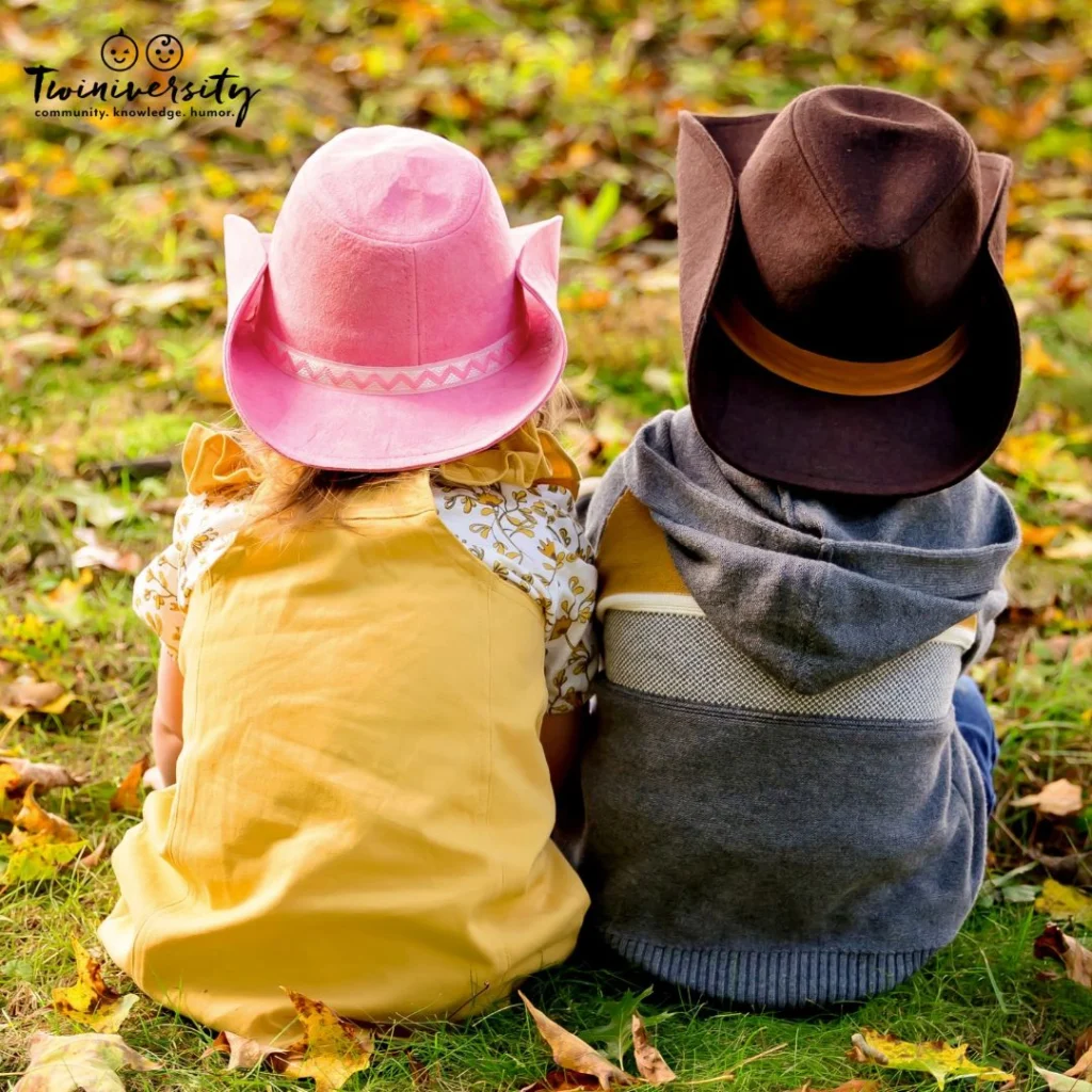 Boy/girl twins sitting together and wearing cowboy hats