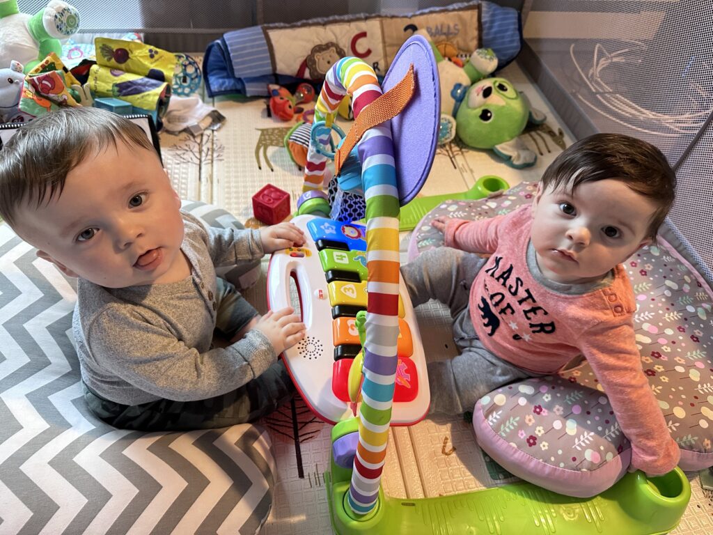 twin babies playing with noisy toy