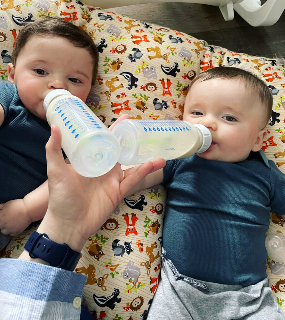 Twins feeding by bottle side by side