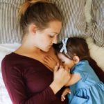 mom breastfeeding a baby lying on a bed feeding twins