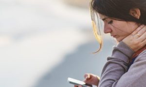 woman sad looking at phone peer pressure