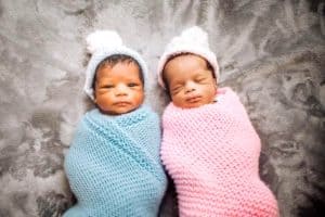 newborn boy girl twins laying down in swaddles twin parents